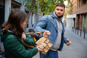 Street thief stealing handbag of woman