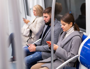 Fototapeta na wymiar Man and woman using phone inside subway