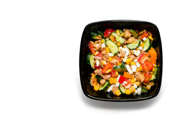Tasty vegetable salad with chicken in a black plate Isolated on white background