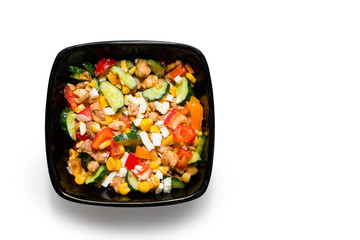 Tasty vegetable salad with chicken in a black plate Isolated on white background
