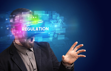 Obraz premium Businessman looking through Virtual Reality glasses with REGULATION inscription, innovative security concept