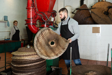 Fototapeta na wymiar Man applying olive paste to fiber mats