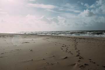 Meer und Wellen am Strand mit Fußspuren