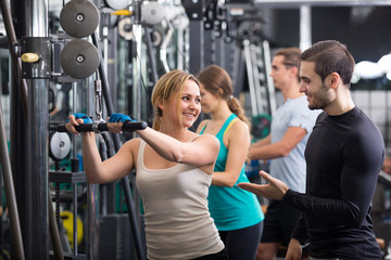 Young adults working out in fitness club.