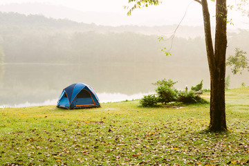 Camping tent by a lake with mist at sunrise Jedkod-Pongkonsao Natural Study in Saraburi Thailand	