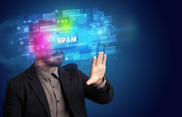 Businessman looking through Virtual Reality glasses with SPAM inscription, innovative security concept