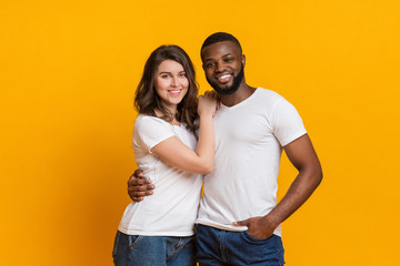 Portrait of romantic interracial couple cuddling and posing together