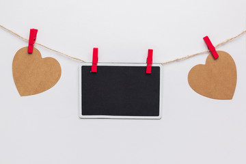 Stock photo of paper hearts and a blackboard hanging on a white background