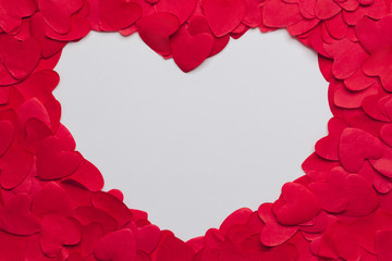 Stock photo of piled paper hearts and a heart-shaped space for text
