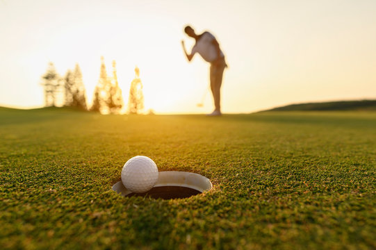 lifestyle, golf, activity, outdoor, sport, golfer concept. Golf balls that are going to be hole by golfers at the green grass golf course at sunset.