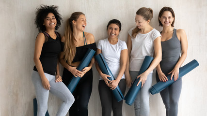 Beautiful diverse women with yoga mats posing for portrait