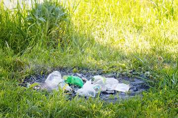 Plastic bottles are recycled on green grass. A pile of plastic on green grass. Melted plastic bottles