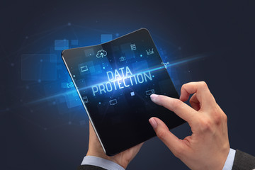 Businessman holding a foldable smartphone with DATA PROTECTION inscription, cyber security concept
