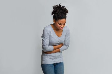 Young black woman having menstrual abdominal pain - obrazy, fototapety, plakaty