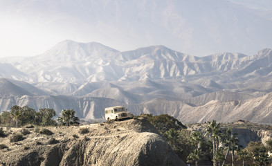 Suv vehicle on Desert landscape with dunes and sand. Adventure road 4x4 off road track. Tabernas desert in Almería - Spain. Desert oasis with palm trees. © Adrian