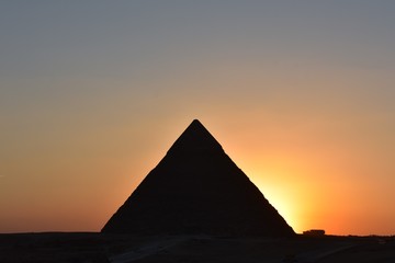 Fototapeta na wymiar sunset behind khafre pyramid shiloutte pyramid with orange light