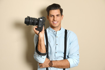 Professional photographer working on beige background in studio