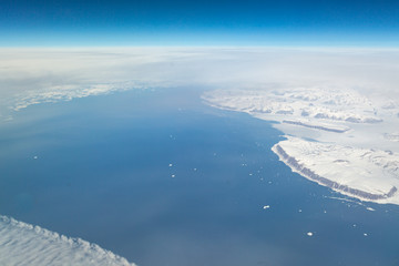 An aerial view of a frozen Greenland landscape, taken from an airplane