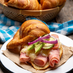 Butter croissant bread with ham and cheese on wooden background