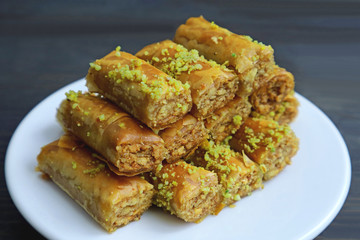 Plate of Baklava Pastries with Pistachio Nuts Served on Wooden table