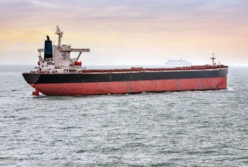 cargo ship sailing at sunset