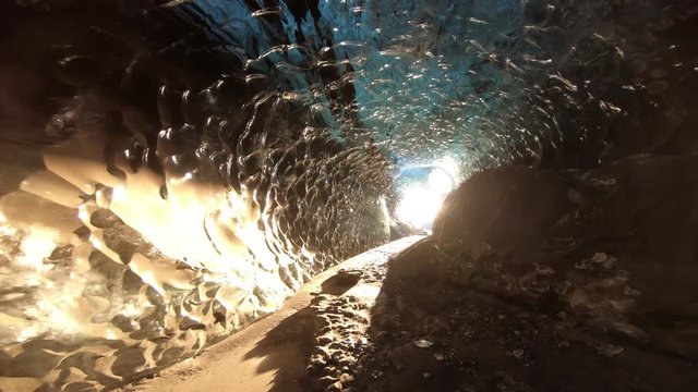 Walking through dark ice caves in Iceland glacier