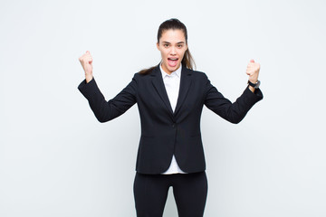 young pretty woman celebrating an unbelievable success like a winner, looking excited and happy...