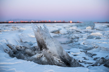 A large block of ice in close-up. Fields of ice hummocks with heaps of large blocks of ice. Winter landscape of a frozen river.