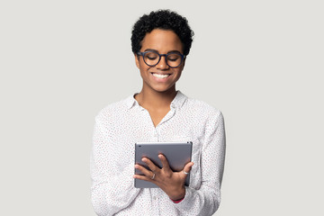 African woman holding tablet do remote online work studio shot