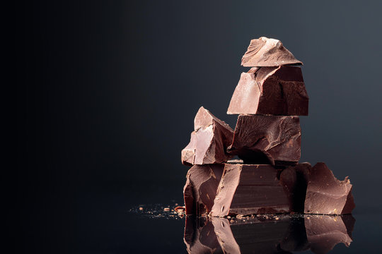 Pieces of dark chocolate on a dark background.