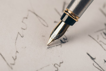 Fototapeta premium Fountain pen on an ancient handwritten letter. Old story. Retro style.