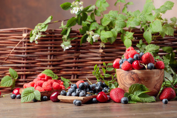 Berries closeup colorful assorted mix of strawberry, blueberry, raspberry and sweet cherry on a old wooden table.