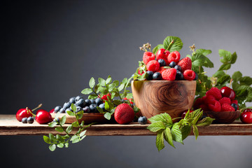 Berries closeup colorful assorted mix of strawberry, blueberry, raspberry and sweet cherry on a old wooden table.