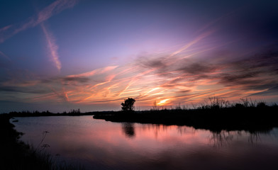 Spectacular sunrise reflected in the lakes at the wetlands of de Groote Peel, Limburg, the Netherlands. National Park on the border between Limburg and North Brabant, close to Meijel. Beautiful clouds