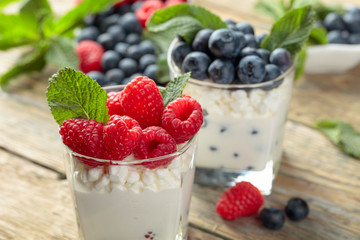 Cottage cheese with cream, raspberry and blueberry garnished with fresh mint.