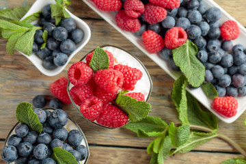 Cottage cheese with cream, raspberry and blueberry garnished with fresh mint.