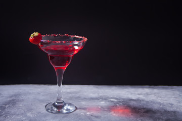 Red exotic alcoholic cocktail in clear glass on the concrete background for romantic dinner.