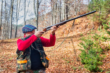 hunter with weapon chasing in the forest