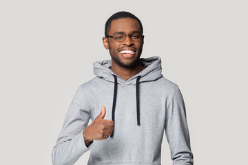 African guy showing thumbs up pose isolated on gray background