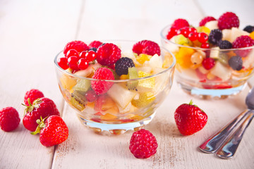salad with fresh fruits and berries on a bowls on the white background