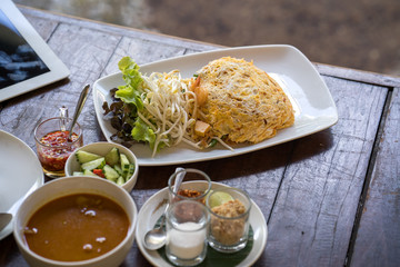 set fried noodle with egg on wooden table.