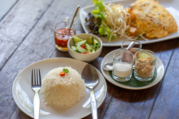 set fried noodle with egg on wooden table.