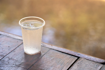 Glass ice water on wooden table.
