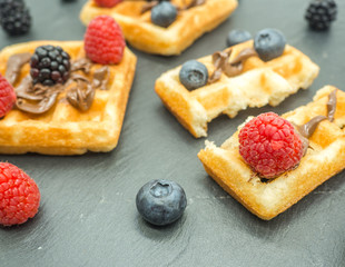 delicious breakfast of waffles with forest berries on slate