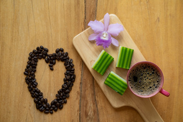 Obraz na płótnie Canvas Cup coffee, Steamed Pandan Layer Cake on wooden tray.