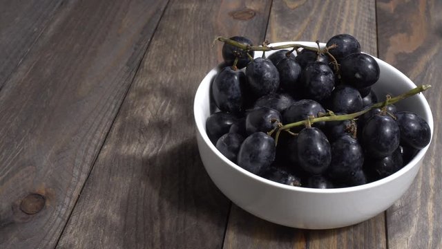 Uvas negras en un bol en la mesa