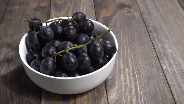 Uvas negras en un bol en la mesa