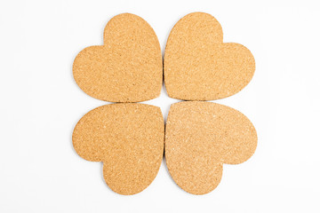 Shape with four hearts made from light brown textured cardboard, isolated on white with space for text
