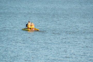 Catamaran slides in the evening on the surface of the Sea. Family at sea walk.