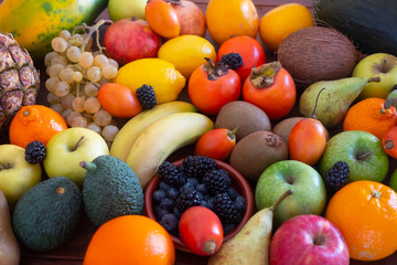 Background of freshly picked fresh fruit mix. Many vitamins together on a wooden table.